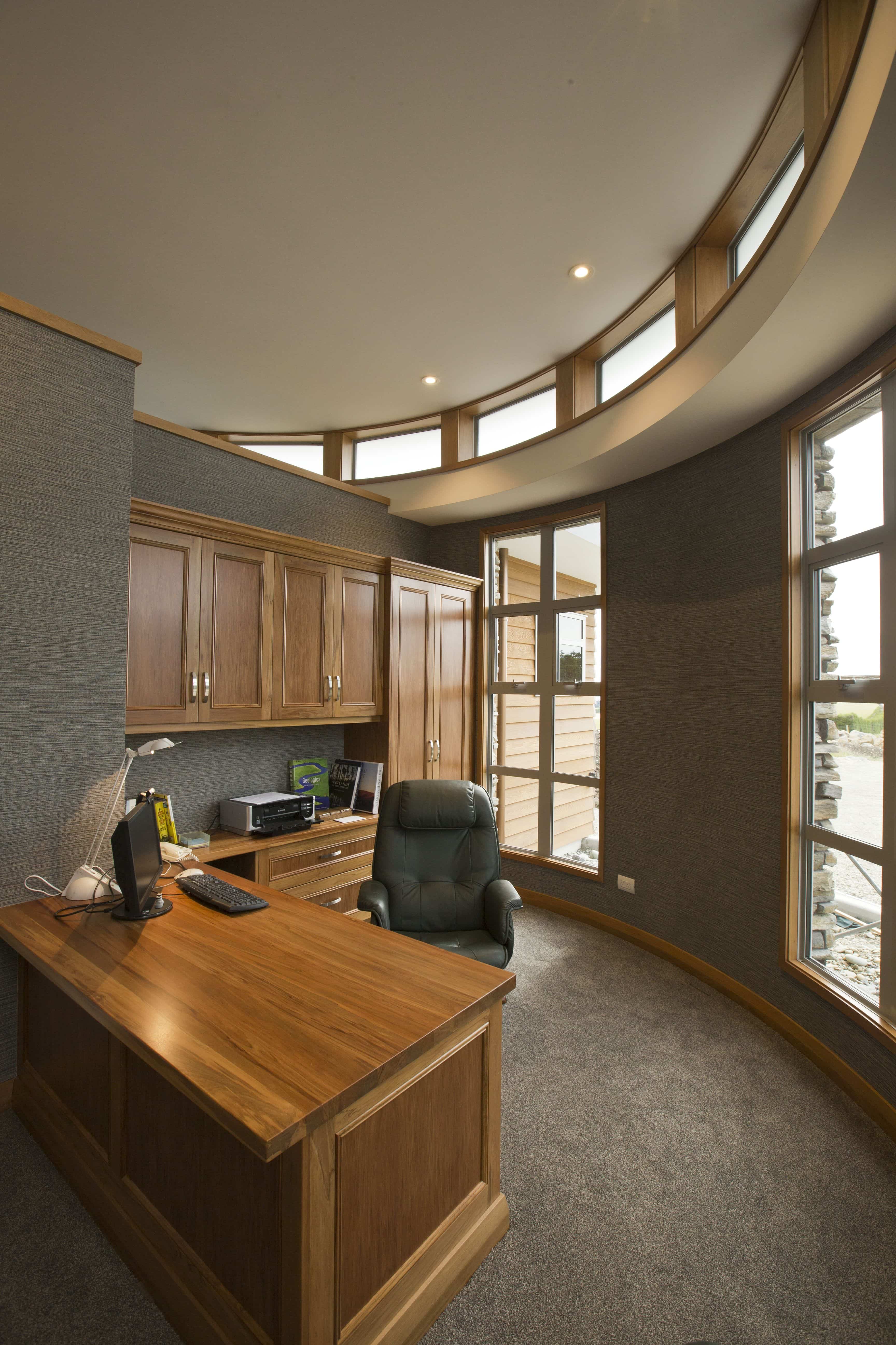  This beautiful home office has textured wallpaper on the curved wall to add interest.