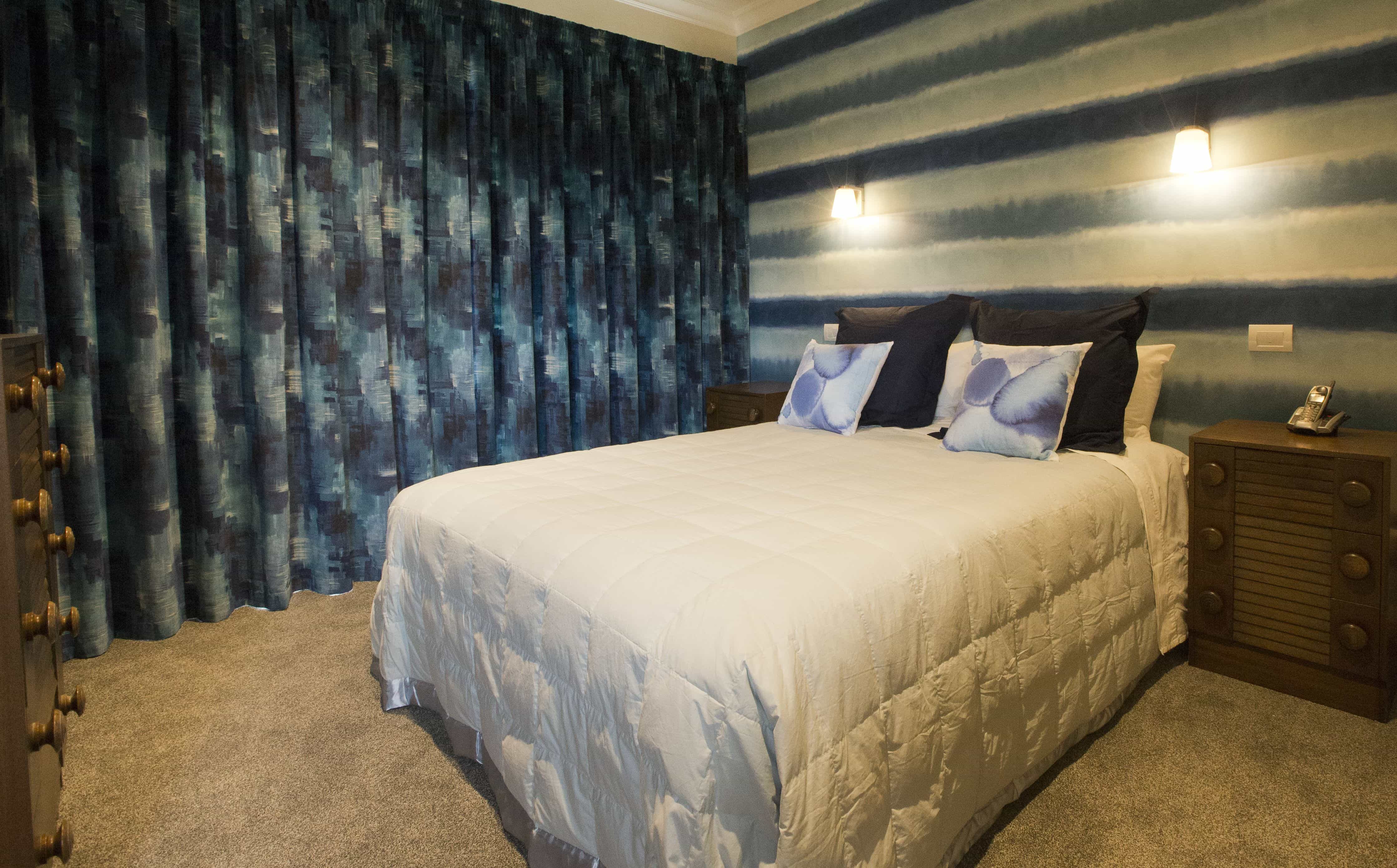 This is a second guest bedroom with wallpaper and curtains blending together