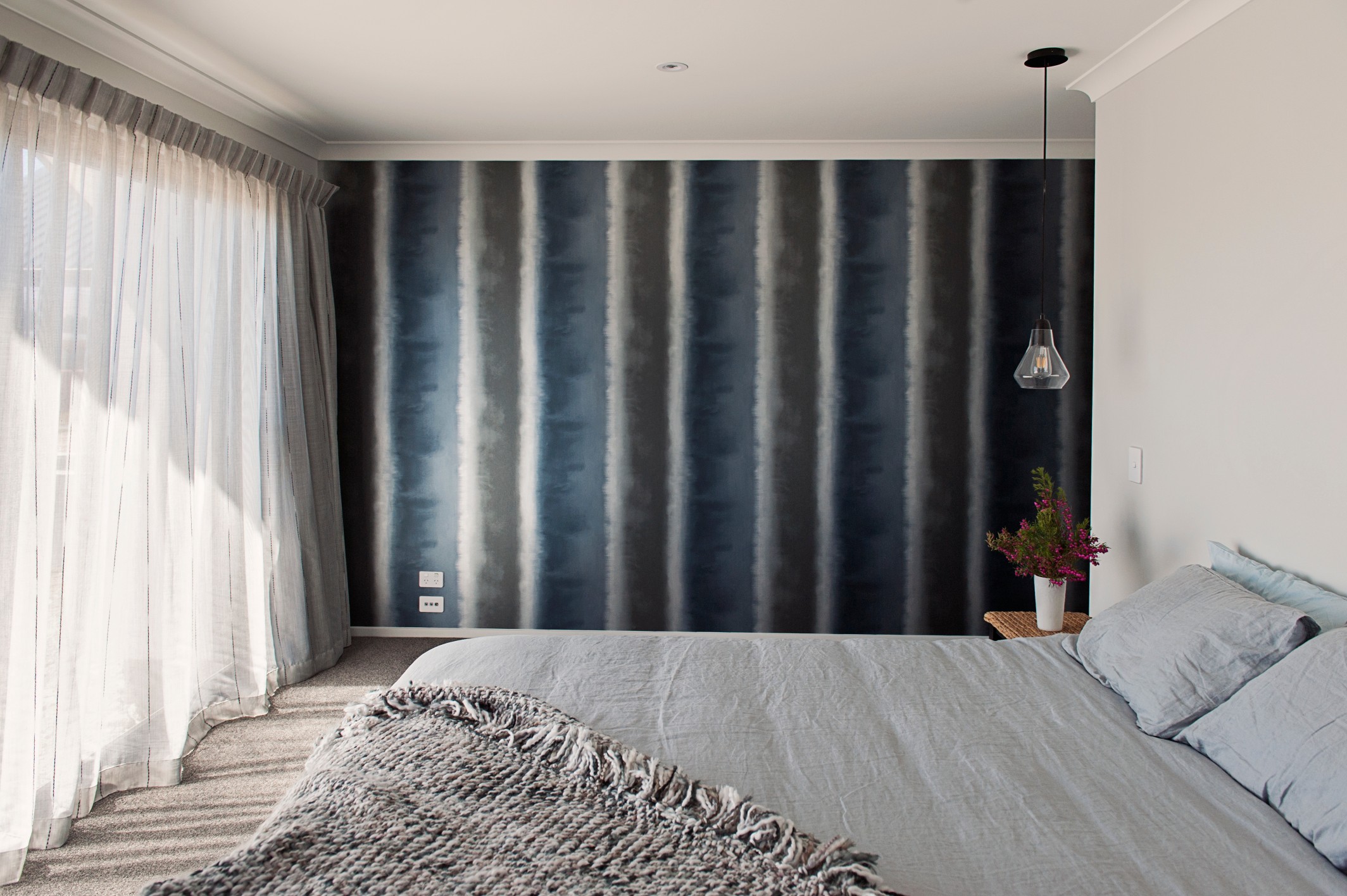  A stripe wallpaper enhances the colours of the main bedroom